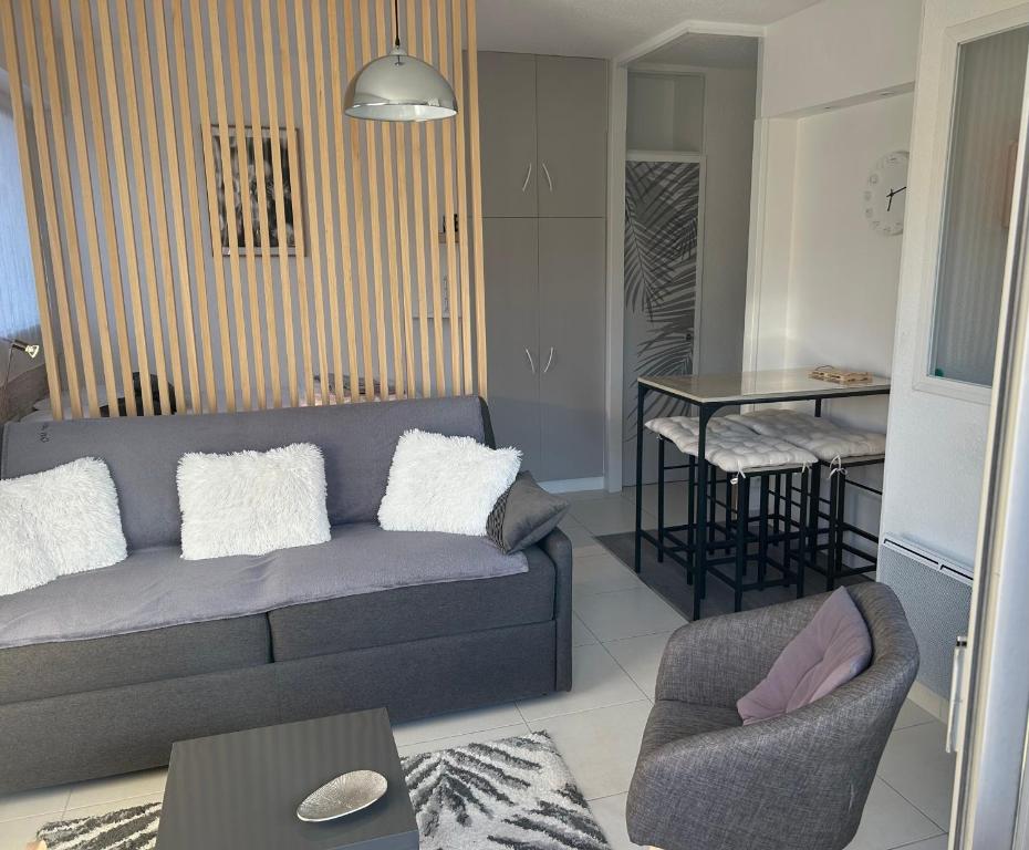 een woonkamer met een bank en een tafel bij LA BAULE : STUDIO MER EN REZ DE JARDIN in La Baule