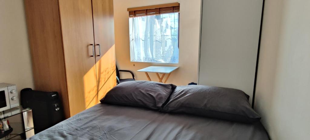 ein kleines Schlafzimmer mit einem Bett und einem Fenster in der Unterkunft Wembley house in London