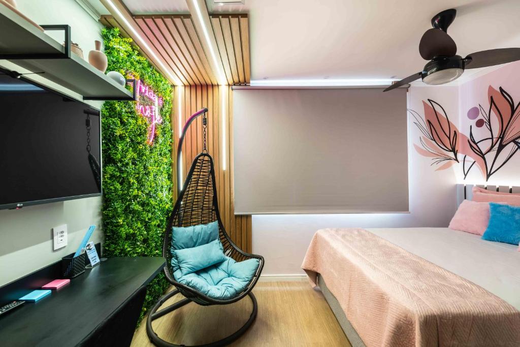 a bedroom with a bed and a chair and a tv at Studio Design Próx ao Metrô Brás com piscina in São Paulo
