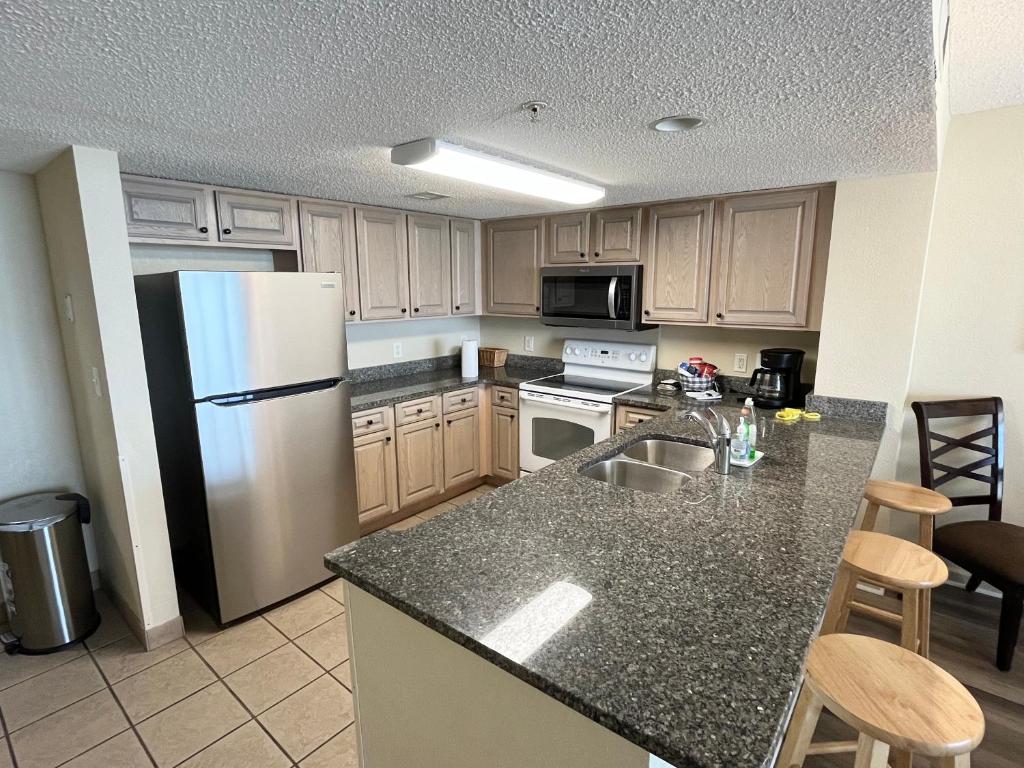a kitchen with a refrigerator and a counter top at Atlantica Resort in Myrtle Beach