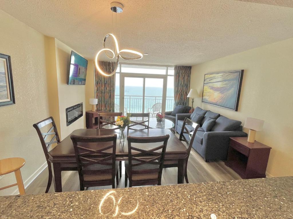 a dining room and living room with a table and a couch at Atlantica Resort in Myrtle Beach