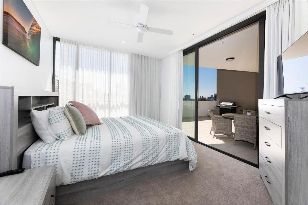 a bedroom with a bed and a sliding glass door at Solaris 312 in Forster