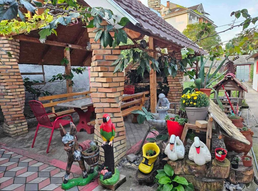 un giardino con statuette di polli e un padiglione di Apartman Centar a Srbobran