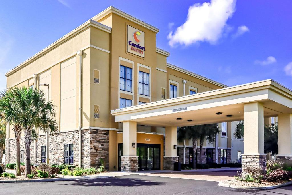 a hotel front of a building with palm trees at Comfort Suites Dunnellon near Rainbow Springs in Dunnellon