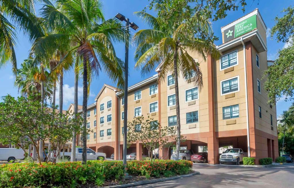a hotel with palm trees in front of a building at Extended Stay America Premier Suites - Fort Lauderdale - Convention Center - Cruise Port in Fort Lauderdale