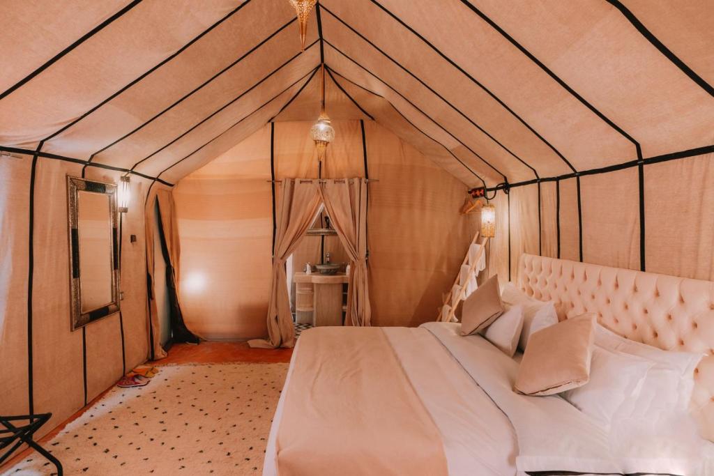 a bedroom with a bed in a tent at desert camp in Adrouine