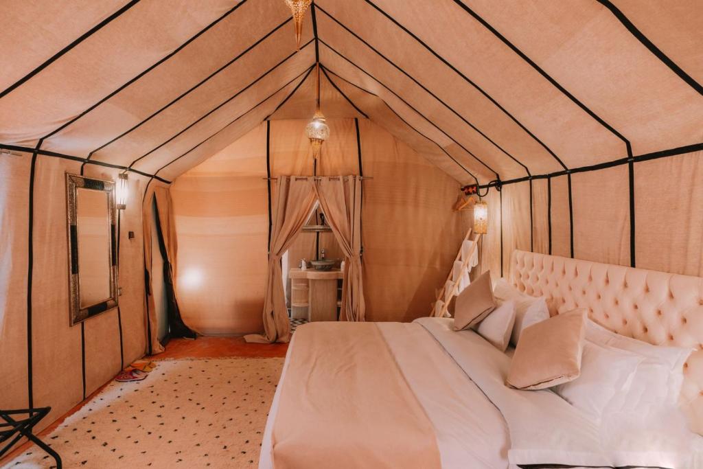 1 dormitorio con 1 cama en una tienda de campaña en desert camp en Hassilabied