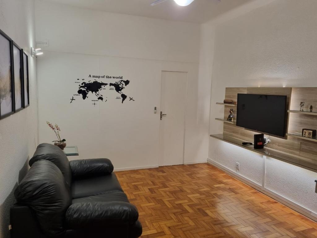 a living room with a black leather chair and a flat screen tv at Apartamento quarto e sala in Rio de Janeiro