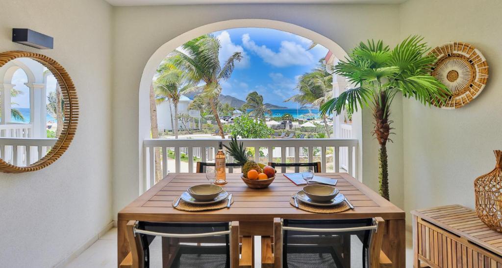 uma sala de jantar com uma mesa e vista para o oceano em Orient bay - Apartment Oceanview - Alamanda beach residence em Orient Bay