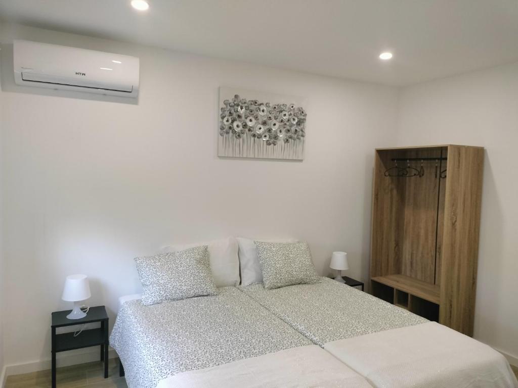 a bedroom with a bed with two pillows at Alojamento Andorinhas in Senhora da Hora