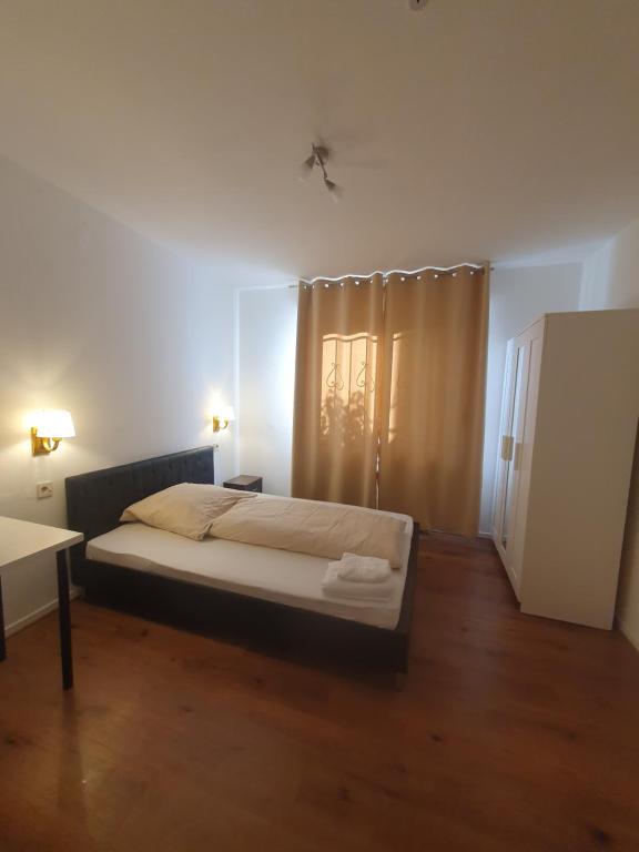 Schlafzimmer mit einem Bett, einem Tisch und einem Fenster in der Unterkunft Gemütliches Privatzimmer an der Uniklinik Mainz. Sehr zentral in Mainz