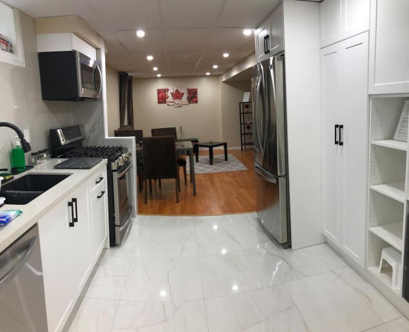 une cuisine avec des appareils électroménagers blancs et une salle à manger dans l'établissement Basement Apartment in Richmond Hill, à Colline De Richmond
