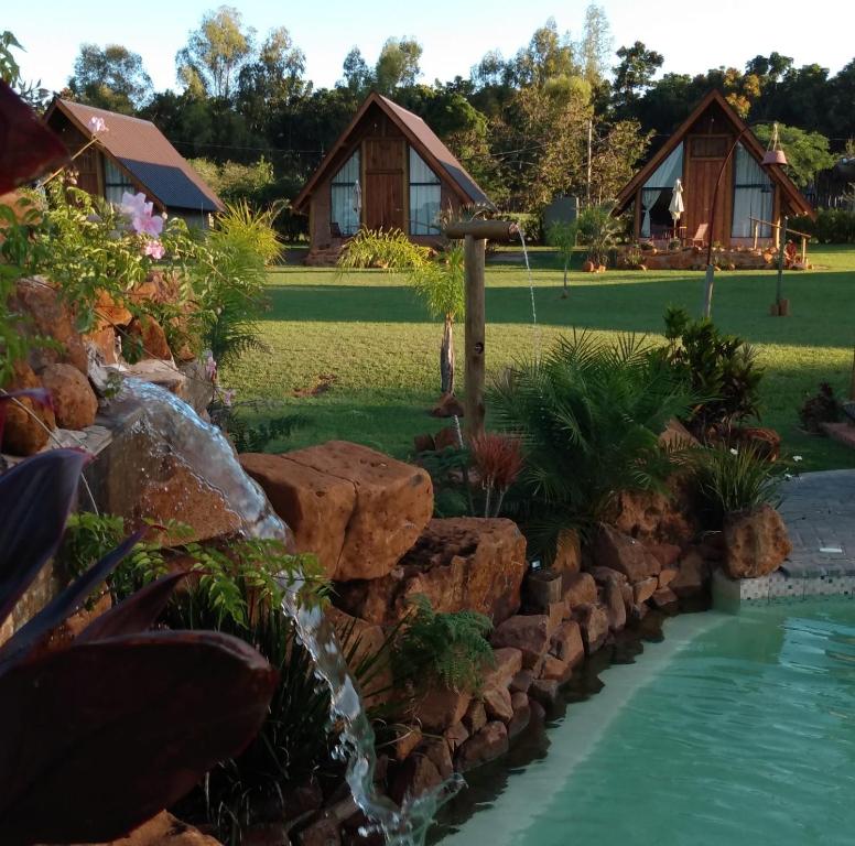 a garden with a waterfall in front of a house at Recanto da Natureza in Brotas