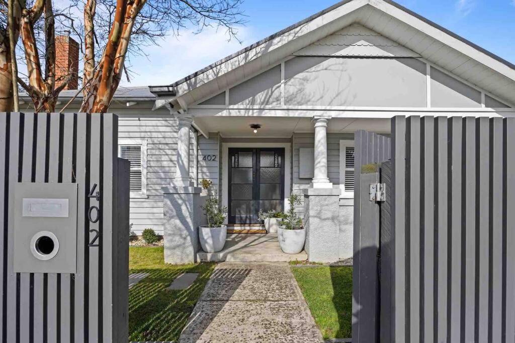 une maison blanche avec une clôture devant elle dans l'établissement House on Drummond, à Ballarat