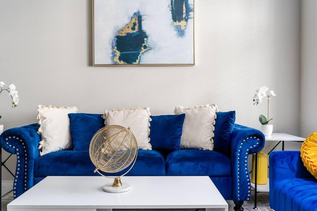 - un canapé bleu avec ventilateur dans le salon dans l'établissement Luxurious 2BD2BA -WFH Equipped, à West Dundee