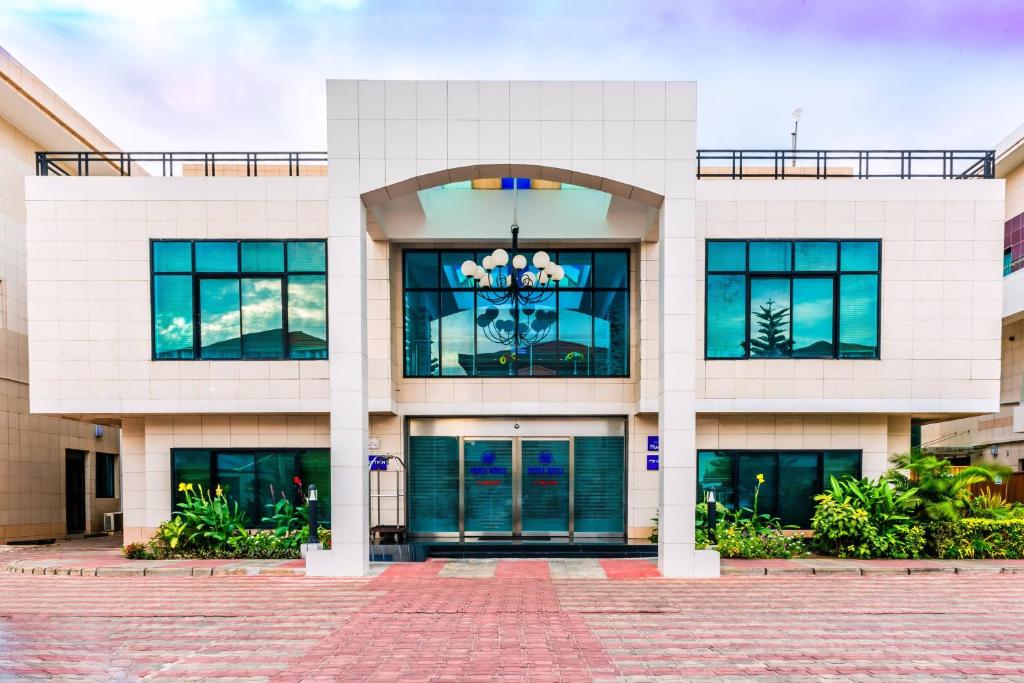 a white building with large windows and doors at Protea Hotel by Marriott Lagos Kuramo Waters in Lagos