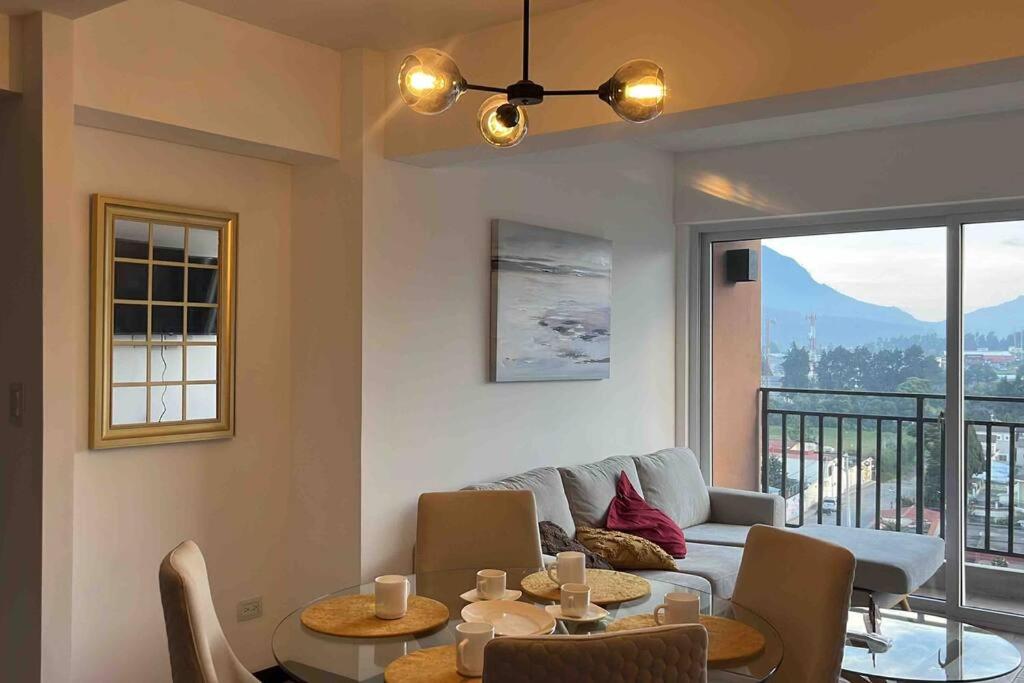 ケツァルテナンゴにあるBonito Apartamento en zona exclusiva y tranquilaのリビングルーム(ソファ、テーブル、椅子付)
