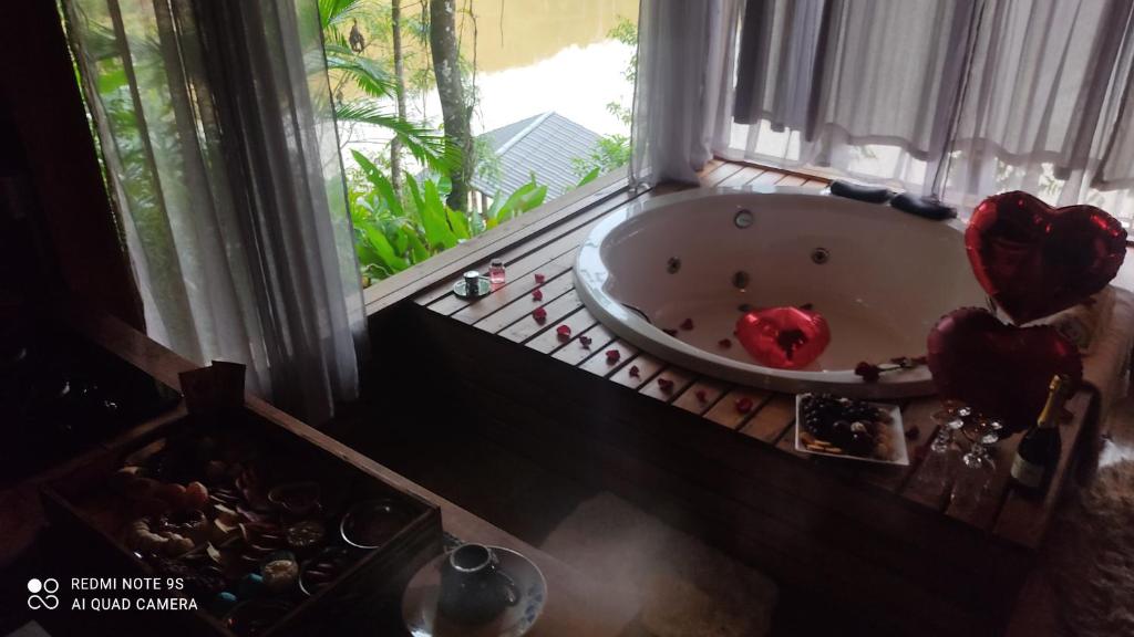 Vila Paraíso في بلوميناو: حوض استحمام في غرفة مع نافذة
