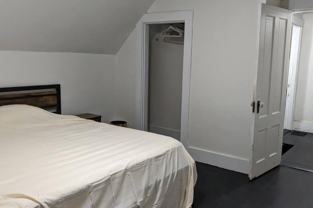 1 dormitorio con cama blanca y armario en Bangor home minutes from airport, en Bangor