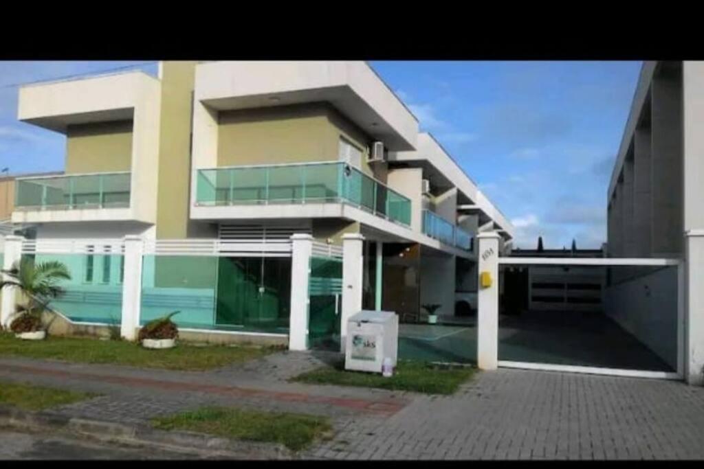 a large building with a parking lot in front of it at Sobrado duas quadras da praia in Guaratuba