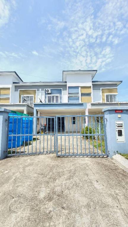 una grande casa con un cancello davanti di Homestay Sri Indah 2 a Kampong Parit