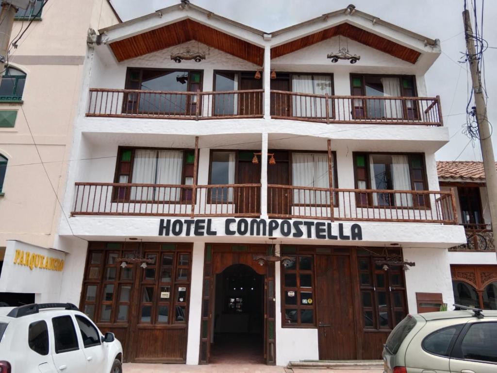 un edificio de compresión de hotel con coches aparcados delante de él en HOTEL COMPOSTELLA en Paipa