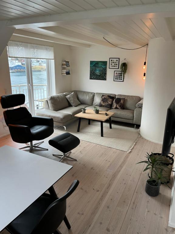 uma sala de estar com um sofá e uma mesa em Apartment downtown - Great View! em Klaksvík