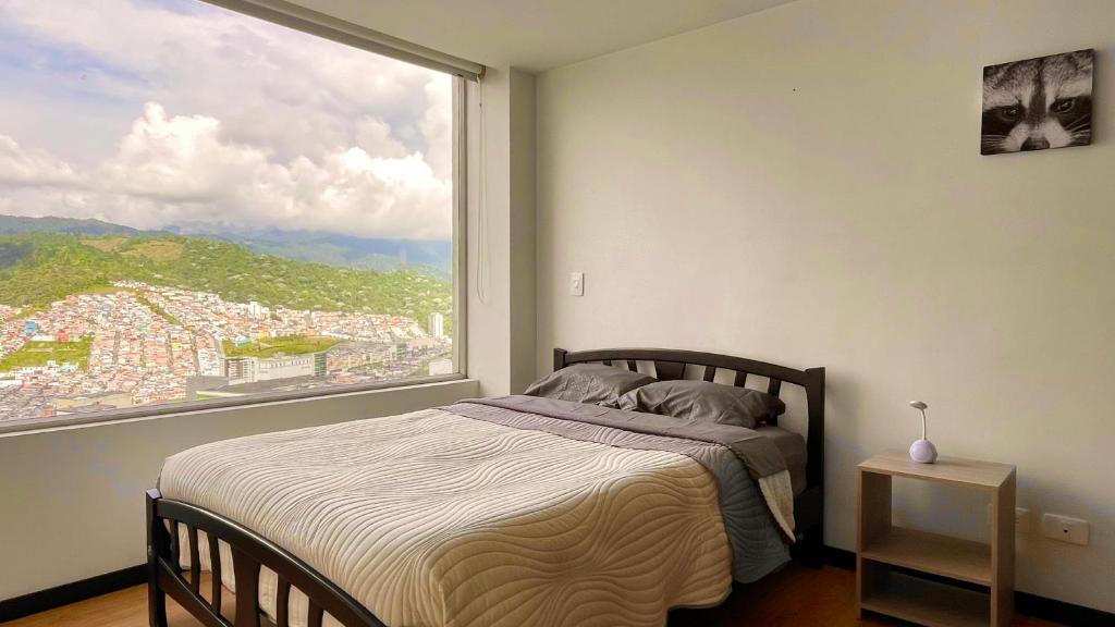 マニサレスにあるAv santander apartamento perfecta ubicaciónのベッドルーム1室(ベッド1台、大きな窓付)