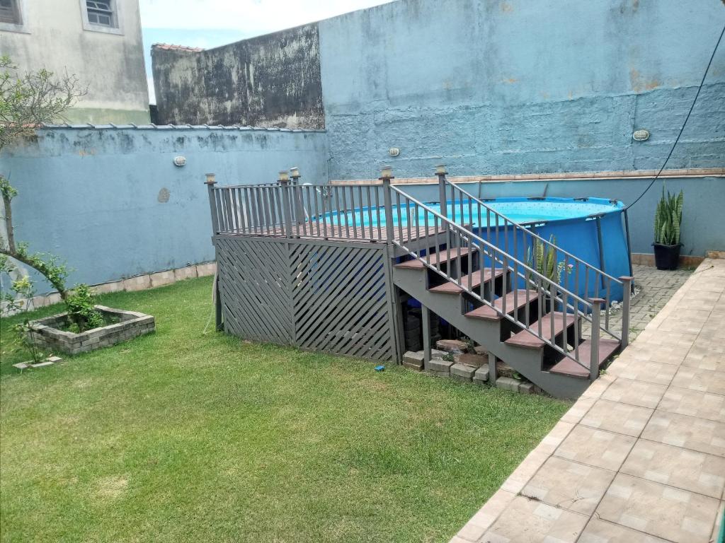 una piscina en un patio junto a una pared azul en Um oásis a 50 metros da praia, en Mongaguá