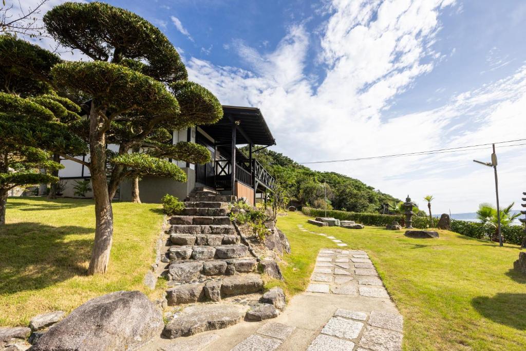 uma casa com escadas que levam a uma casa em Keiko"s Home 宮浦一日一組限定海の絶景オーシャンビューのラグジュアリー別荘2000m2BBQ可海釣公園 em Fukuoka