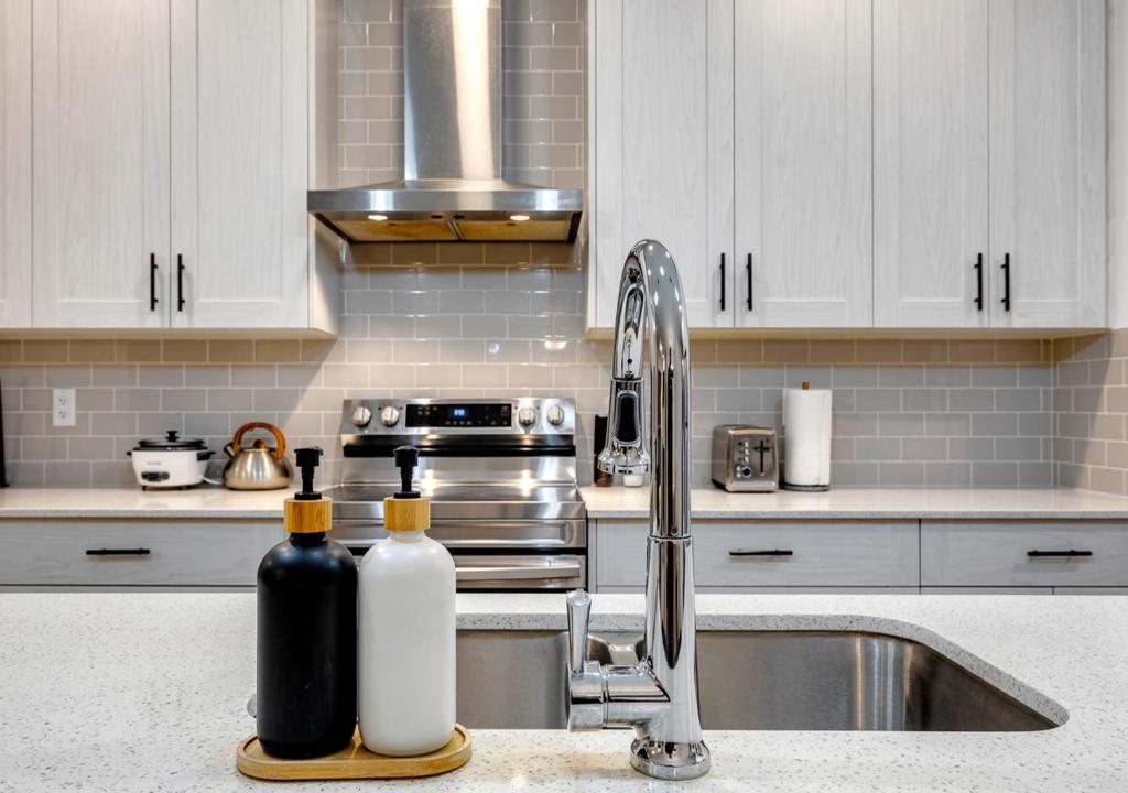 a kitchen with a sink and two bottles on a counter at Stylish/4Bedroom/FreeParking/IndoorFirePlace in Calgary