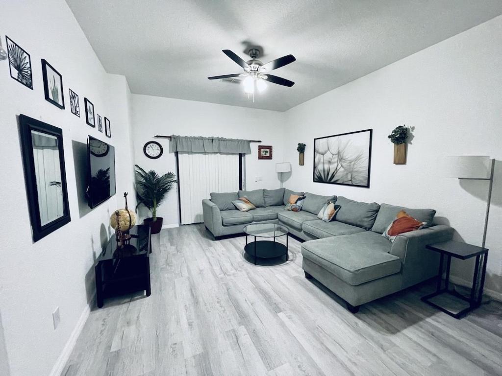 ein Wohnzimmer mit einer Couch und einem Deckenventilator in der Unterkunft Cozy 3 bedroom Condo near Disney World! in Kissimmee