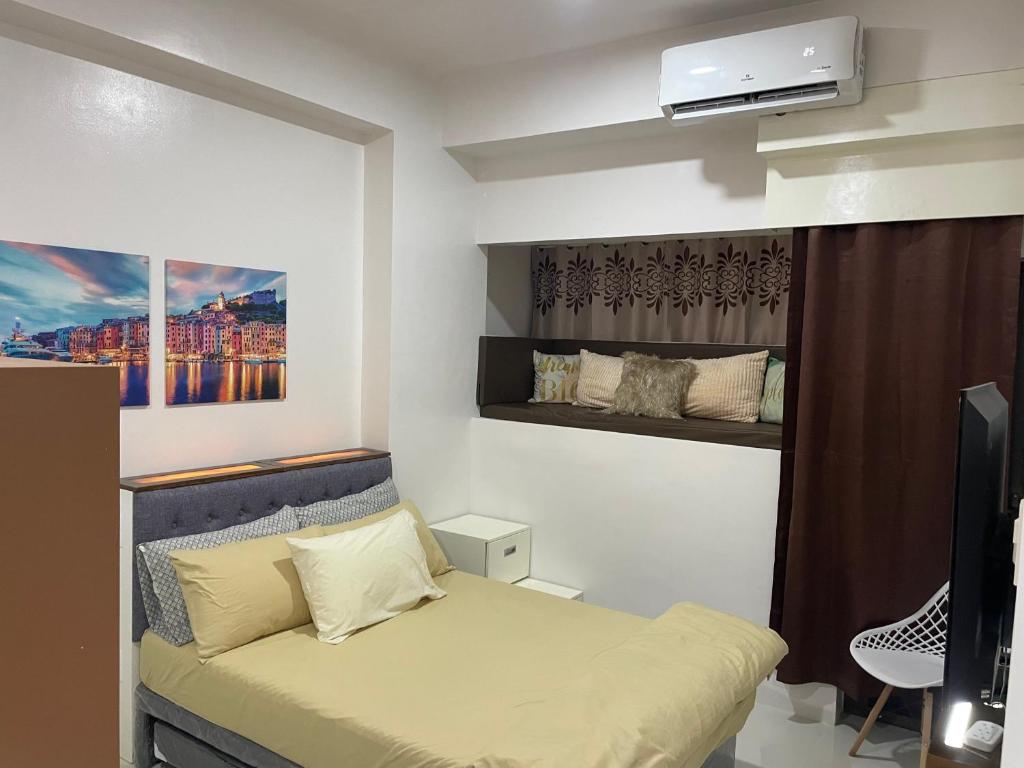 a small bedroom with a bed and a television at WV Tower 1 Studio in Iloilo City