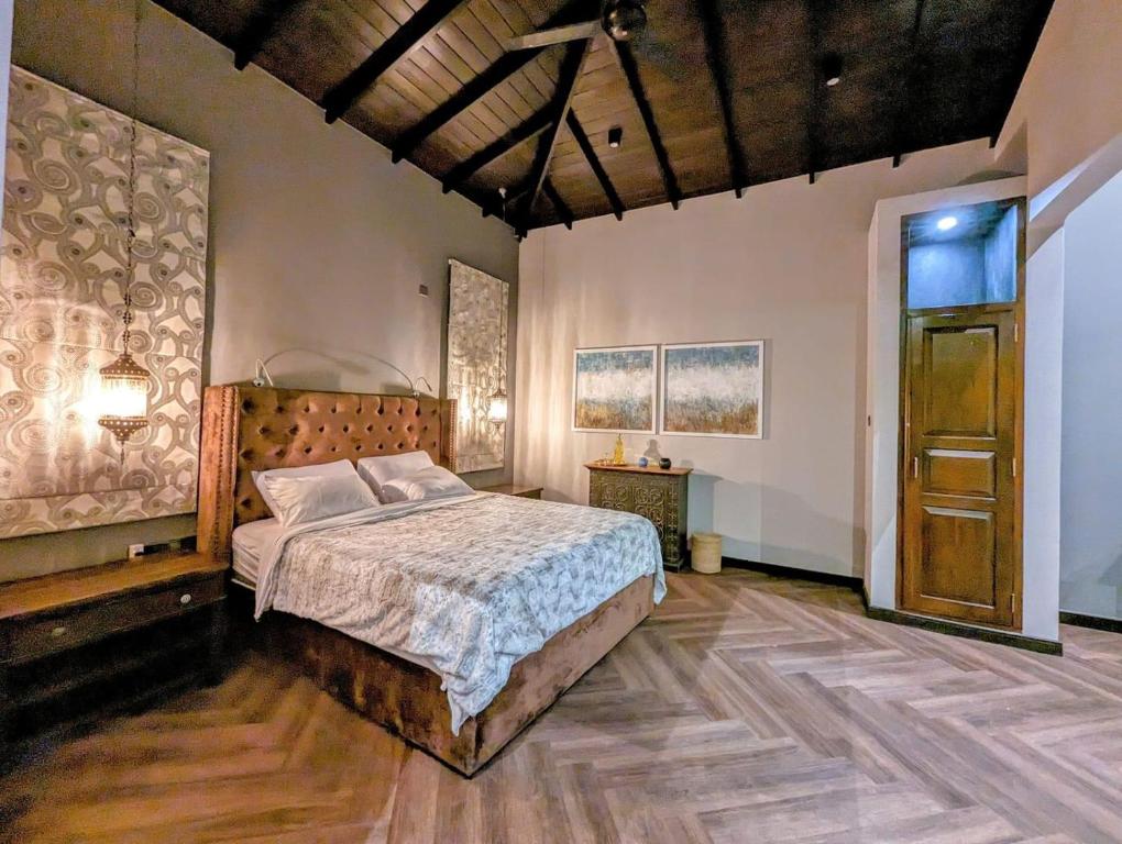 a bedroom with a bed and a wooden floor at Hunnasgiriya Oncloud 9 in Hunnasgiriya