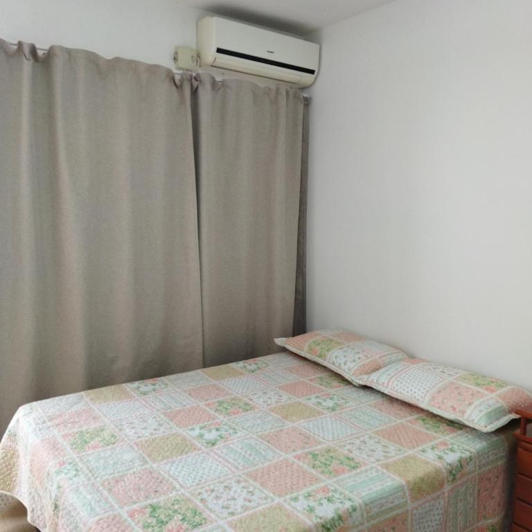 1 dormitorio con 1 cama con cortina y ventana en Suíte com entrada Privativa en Barra Velha