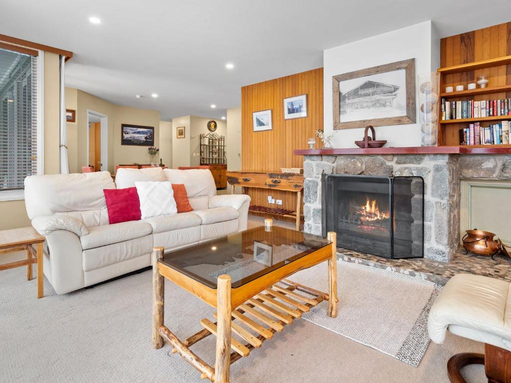 a living room with a couch and a fireplace at Aspect 2 in Thredbo