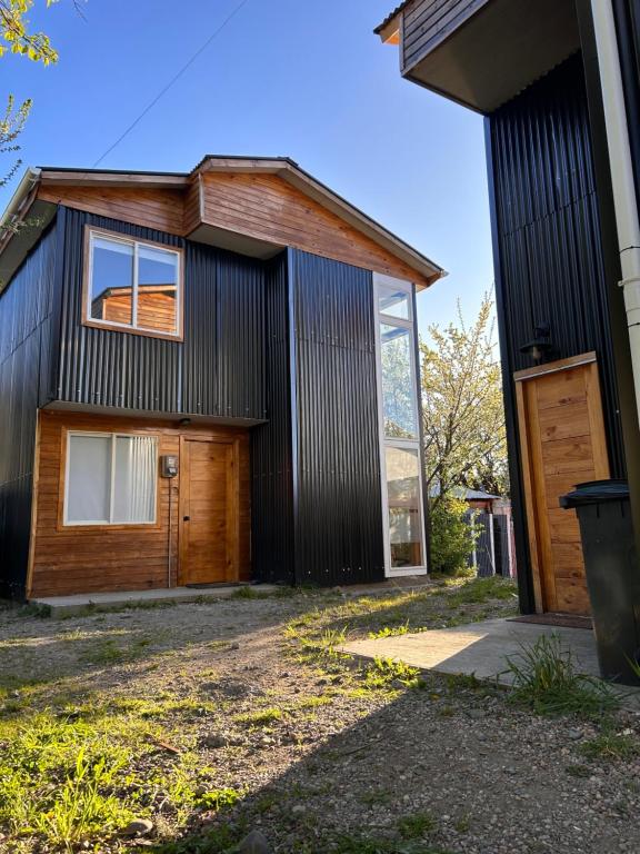 una casa nera con garage e porta di Casas Altos del Simpson a Coihaique