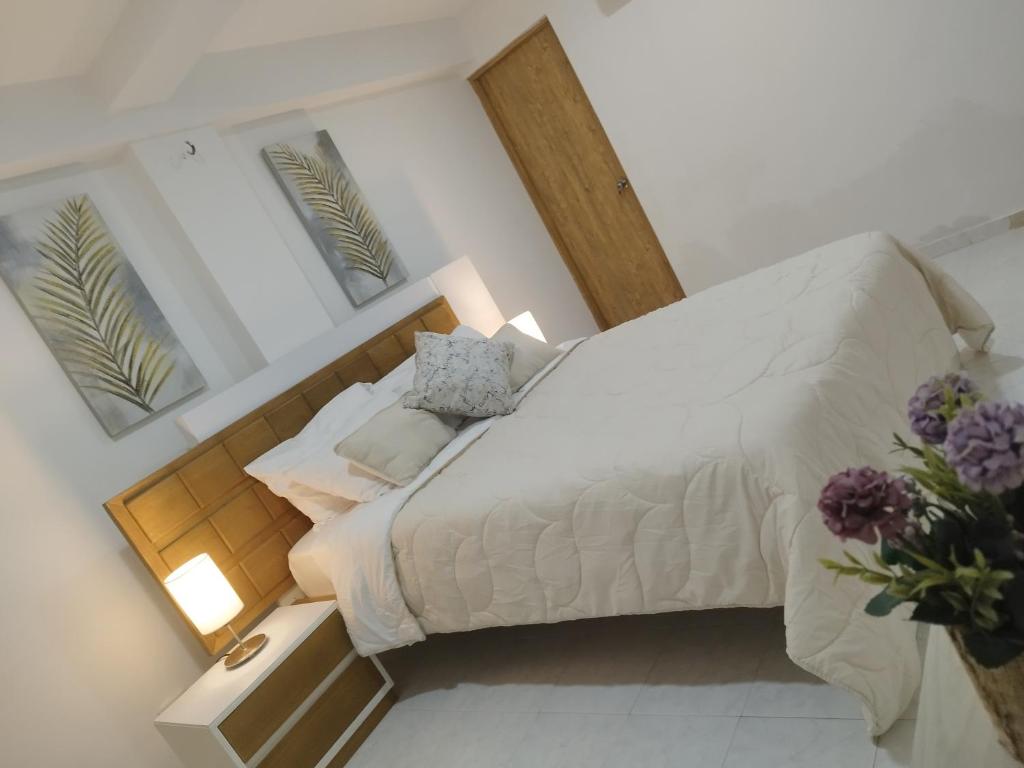 Schlafzimmer mit einem großen Bett mit einem Kopfteil aus Holz in der Unterkunft Apartamento moderno frente al mar in Cartagena de Indias