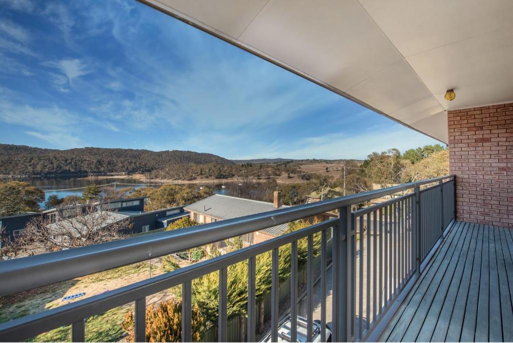 a balcony with a view of a river and mountains at Erulisse in Jindabyne