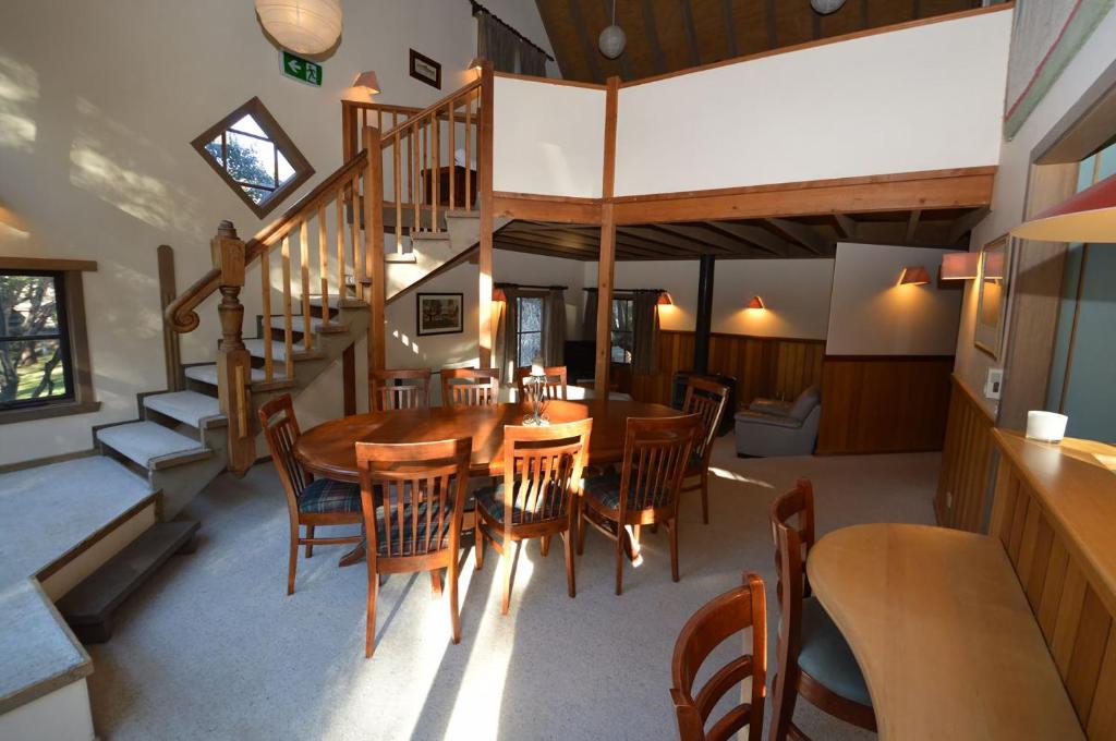 comedor con mesa de madera y sillas en Hi Plains Garadyigan Chalet, en Thredbo