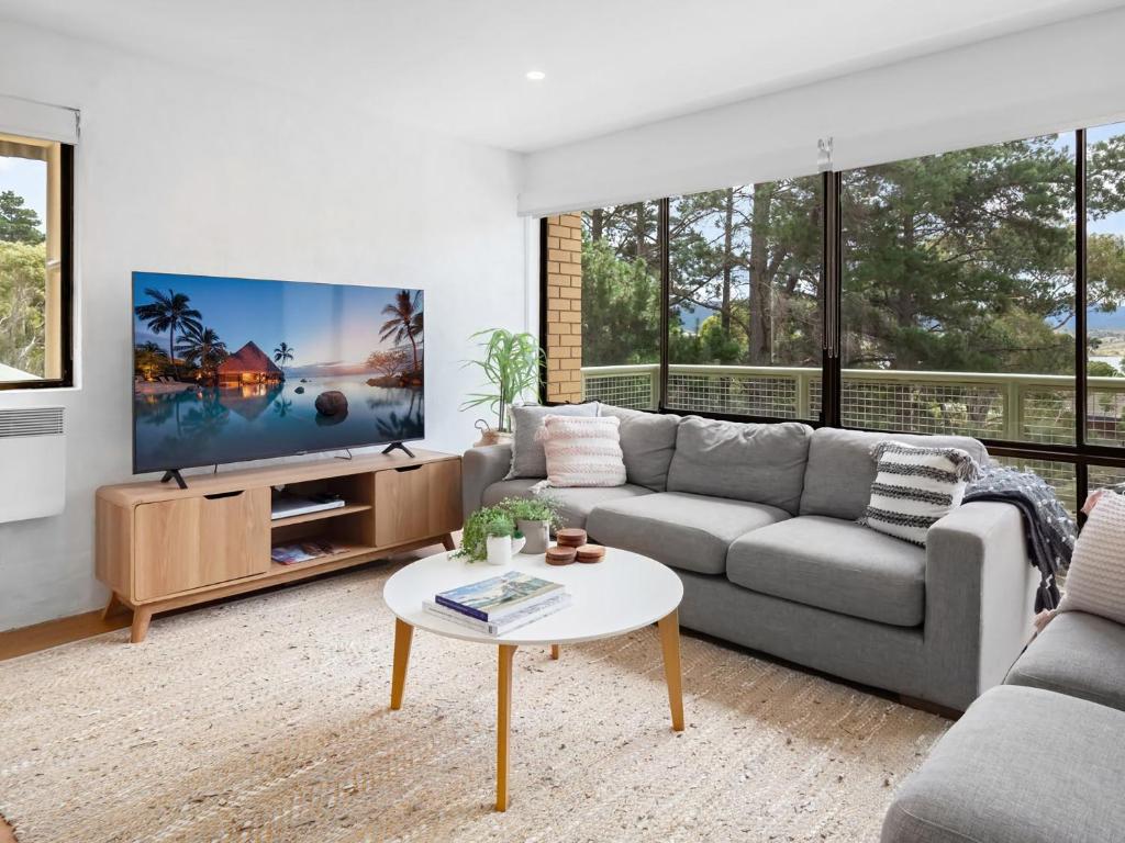 a living room with a couch and a tv at Kirwan 19 in Jindabyne