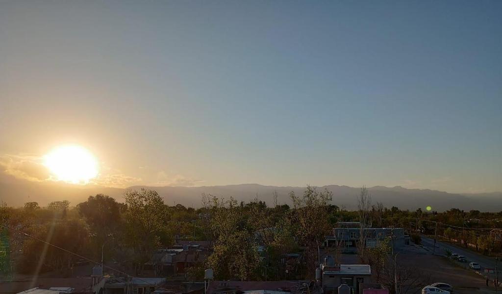 een uitzicht op de zonsondergang boven een stad bij VistAndes alojamiento in Guaymallen