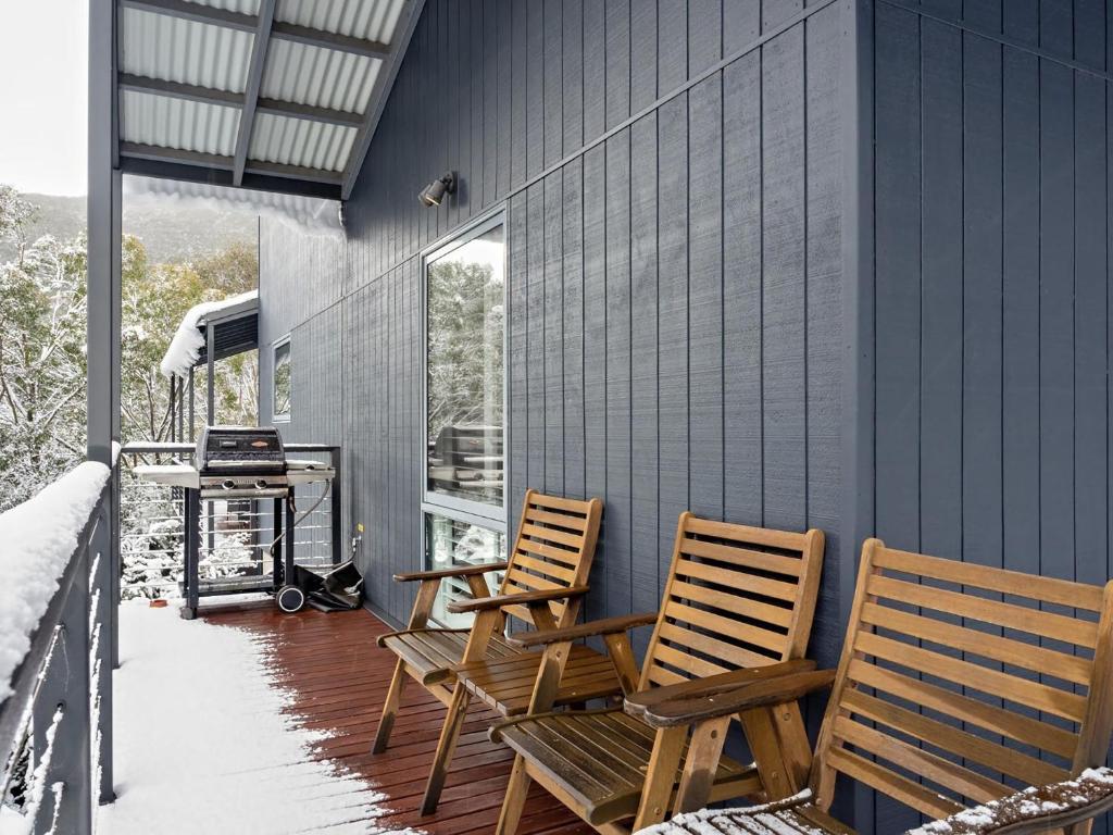 two chairs sitting on a porch in the snow at Snowbound 1 in Thredbo