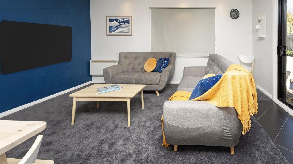 a living room with two chairs and a tv at Yurali in Jindabyne