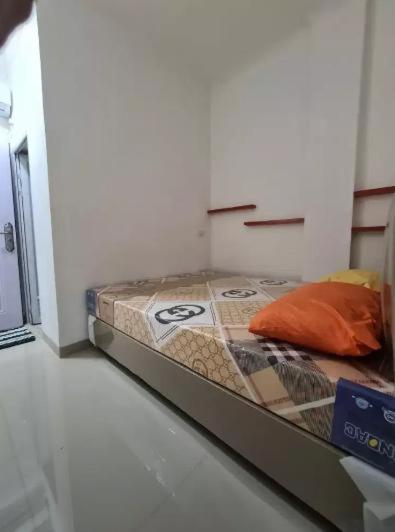 a bed in a corner of a room at Highlander Stay Palembang in Palembang