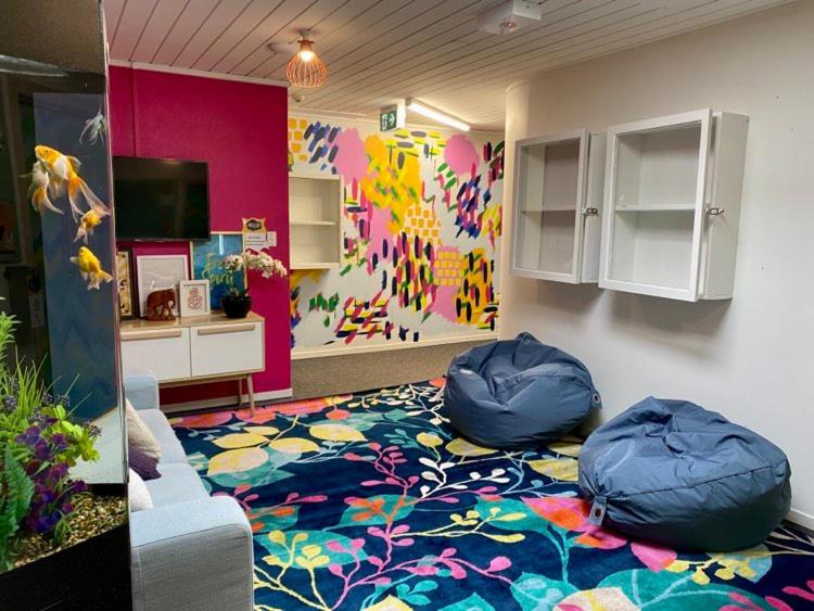 a room with two bean bags on a colorful carpet at Hello! Accommodation in Tauranga