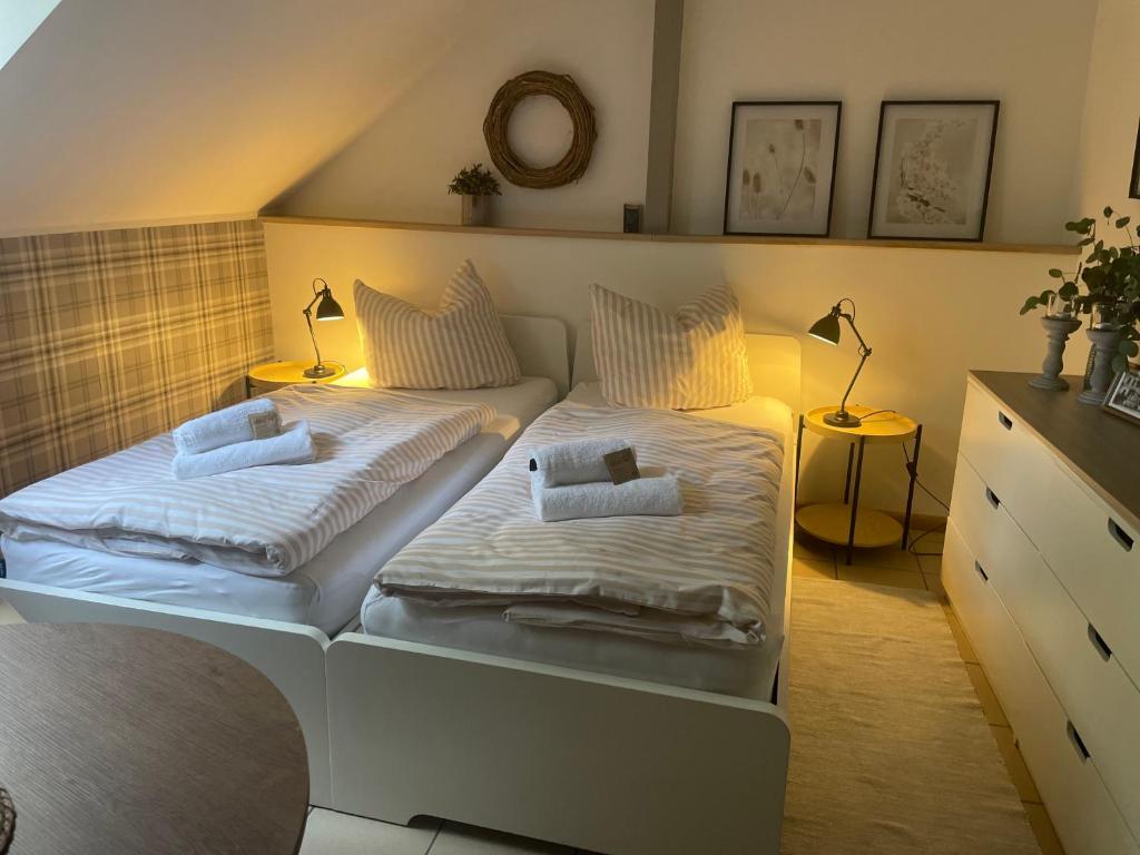 2 Einzelbetten in einem Zimmer mit 2 Lampen in der Unterkunft Weberhof Apartment 6 in Münster
