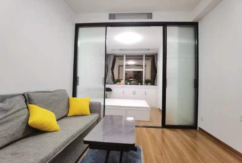 a living room with a couch and a table at House of Great White Apartment in Shenzhen