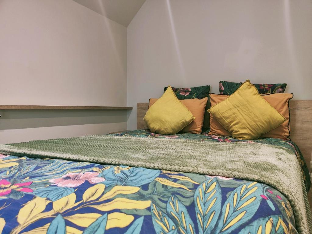 una camera da letto con un grande letto con cuscini colorati di La petite maison a Dinan