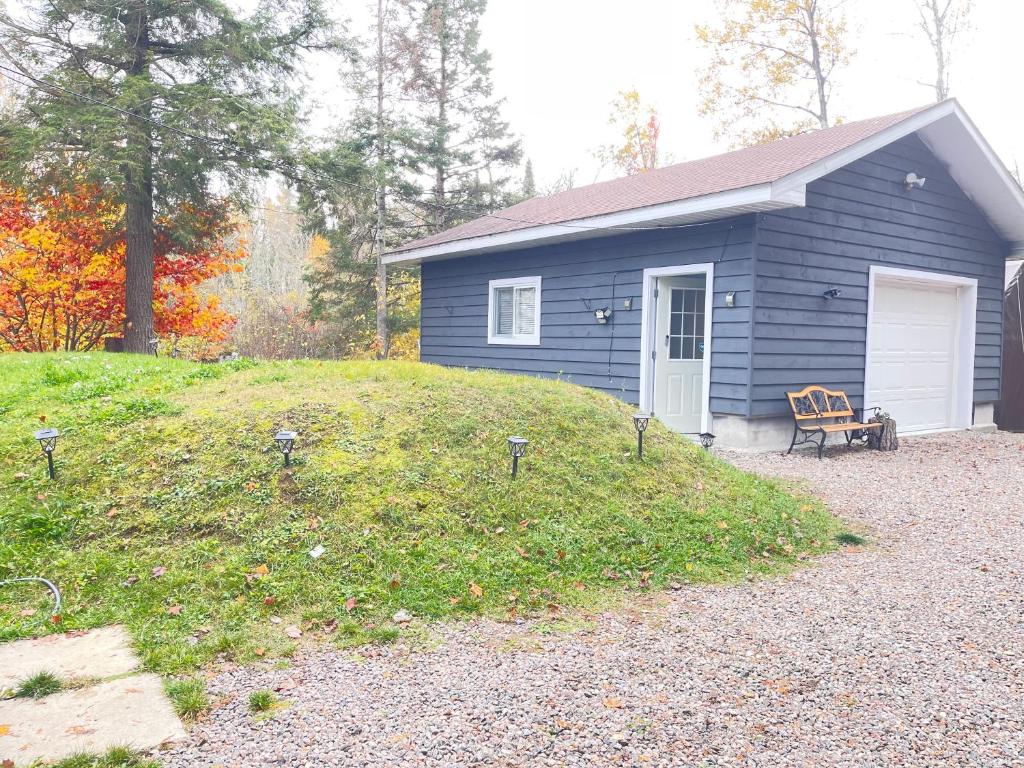 a blue house with a bench in front of it at Janis Guest House 6-8 Guests in Wilberforce